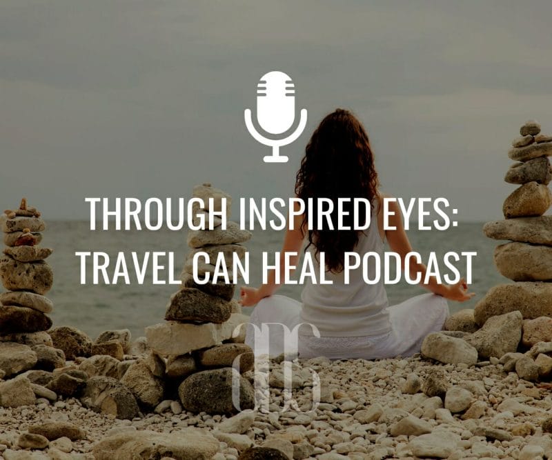 Photo of a woman on the beach in a meditation position with stacked rock sculptures on the sand, microphone icon, text that says Through Inspired Eyes: Travel Can Heal Podcast