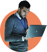 A man with short dark hair and a beard, wearing a blue sweater over a collared shirt and a lanyard, stands holding and looking intently at a laptop—focused on conducting an ADA Website Compliance Audit—against an orange circle backdrop.