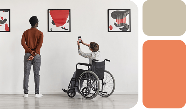 Man on wheelchair in gallery taking picture of painting