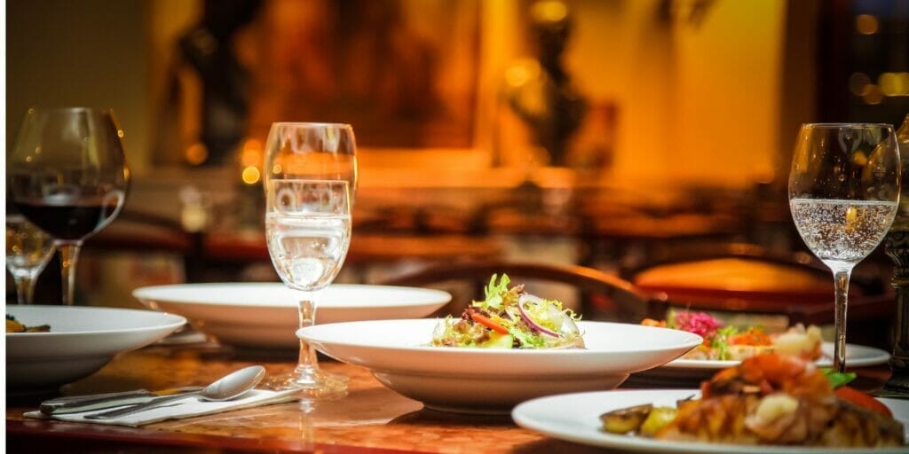 a table with plates of food and wine glasses on it