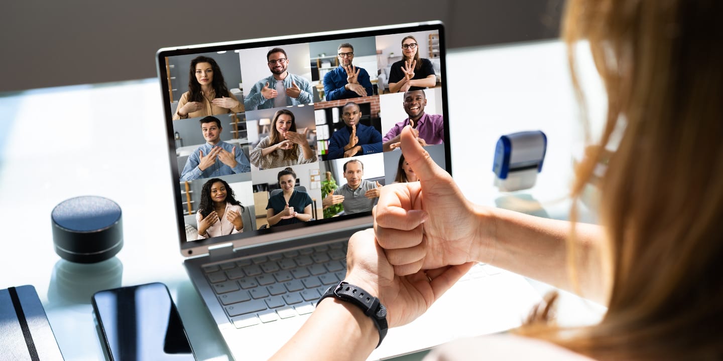 A man having sign language communication over a video conference call with a group of people